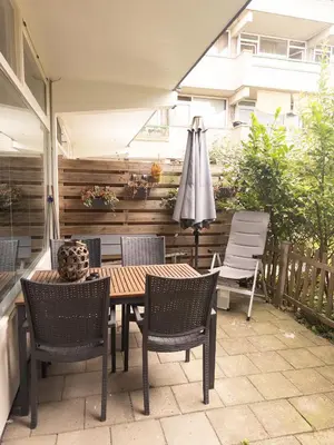 a patio with a table and chairs and an umbrella at De Schelp 86, Garden and Free parking in Zandvoort