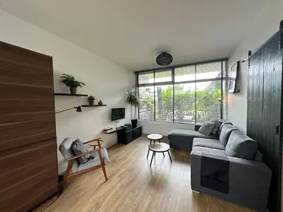 a living room with a couch and a table at De Schelp 86, Garden and Free parking in Zandvoort