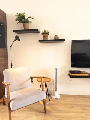 a living room with a chair and a television at De Schelp 86, Garden and Free parking in Zandvoort