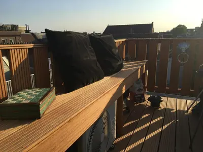 a wooden bench on a balcony with a pillow at Studio Jordaan Amsterdam City Centre in Amsterdam