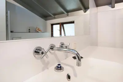 a white bathroom with a sink and a mirror at Bed and breakfast private accommodation at Amsterdam Houseboat in Amsterdam