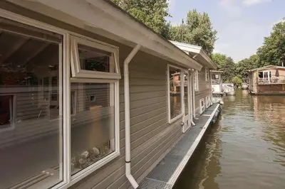 a house on the water next to a river at Bed and breakfast private accommodation at Amsterdam Houseboat in Amsterdam