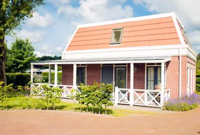 a small red brick house with a porch at Tulp en Zee in Noordwijk