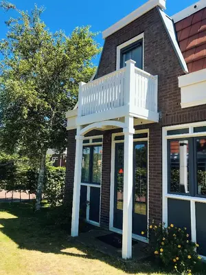 a house with a balcony on the side of it at Tulp en Zee in Noordwijk
