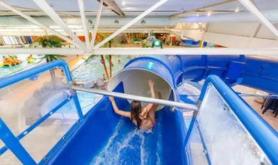 a girl is going down a water slide at a water park at Tulp en Zee in Noordwijk