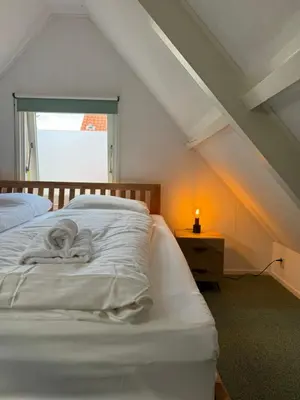 a room with two beds and a window at Beachhouse De Dahlia in Noordwijk aan Zee