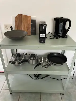 a shelf with pots and pans on it at Beachhouse De Dahlia in Noordwijk aan Zee