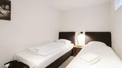 two beds in a room with white sheets at Dutchen Vakantiepark Duynvallei in Schoorl
