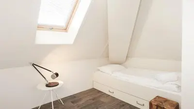 a small bedroom with a bed and a window at Dutchen Vakantiepark Duynvallei in Schoorl