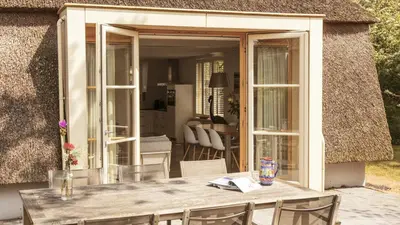 a table and chairs in front of a house at Dutchen Vakantiepark Duynvallei in Schoorl