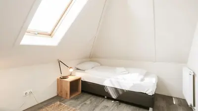 a bed in a room with a window at Dutchen Vakantiepark Duynvallei in Schoorl