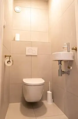 a small bathroom with a toilet and a sink at Sint Adelbertus in Egmond-Binnen