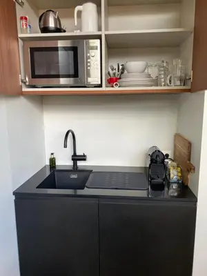 a kitchen counter with a sink and a microwave at M&M guest house in Amsterdam