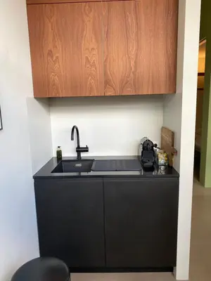 a kitchen with a sink and a wooden cabinet at M&M guest house in Amsterdam