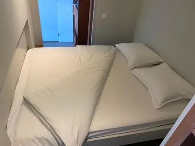 a bed with white sheets and pillows on it at M&M guest house in Amsterdam