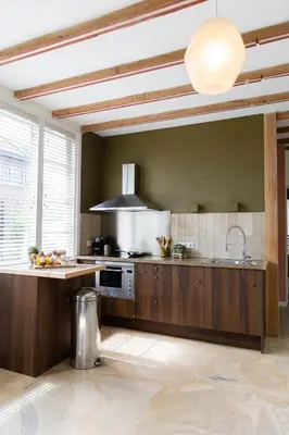 a kitchen with wooden cabinets and a stove top oven at Ben bij Bos in Oude-Niedorp
