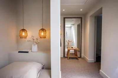 a bedroom with a bed and a hallway with a mirror at Loft 48 in Haastrecht