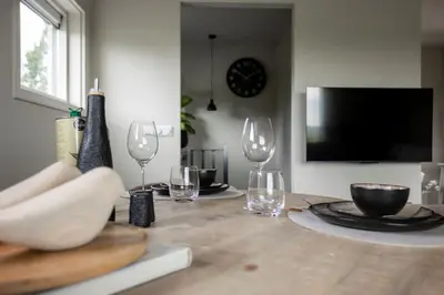 a dining room table with wine glasses and a television at Loft 48 in Haastrecht