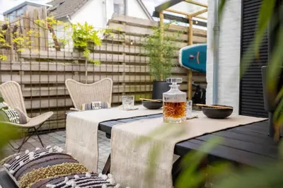 two tables with bowls and a bottle on a patio at Loft 48 in Haastrecht