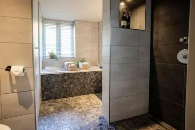 a bathroom with a tub and a sink and a shower at Loft 48 in Haastrecht