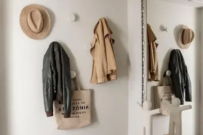 a white wall with a coat and a bag and hats at Loft 48 in Haastrecht