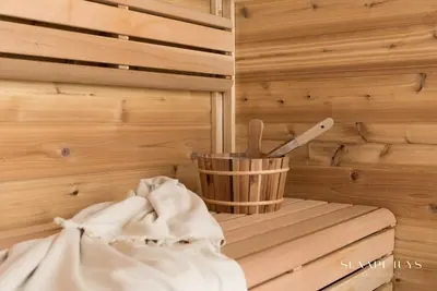 a wooden sauna with a cup and a knife at Slaaphuys Bed & Sauna in Alkmaar