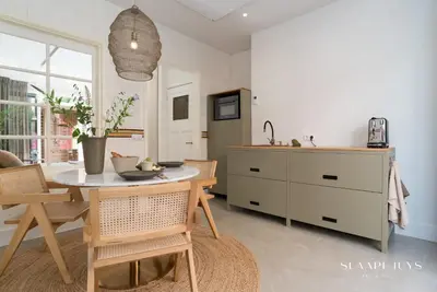 a kitchen with a table and chairs and a sink at Slaaphuys Bed & Sauna in Alkmaar