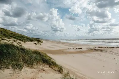 a sandy beach with the ocean on a cloudy day at Slaaphuys Bed & Sauna in Alkmaar