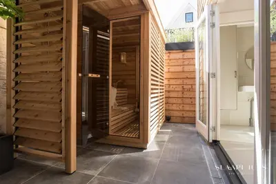 a pivot door in a house with wooden walls at Slaaphuys Bed & Sauna in Alkmaar