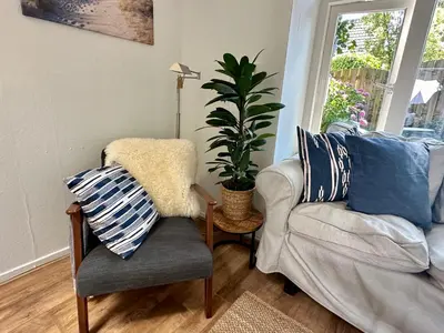 a living room with a chair and a plant at Vakantiehuis Flori in Bergen