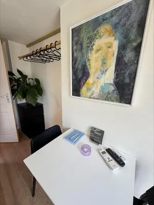 a room with a white table and a painting on the wall at The Hazel House in Haarlem