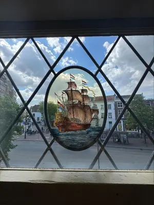 a window with a picture of a ship in the water at The Hazel House in Haarlem