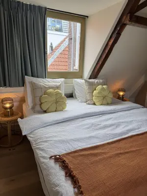 a bedroom with a large white bed with two pillows at The Hazel House in Haarlem