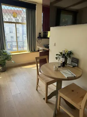 a room with a table and chairs and a stained glass window at The Hazel House in Haarlem