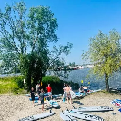 a group of people standing on a beach with surfboards at Houseboat Tomio near Amsterdam in Monnickendam