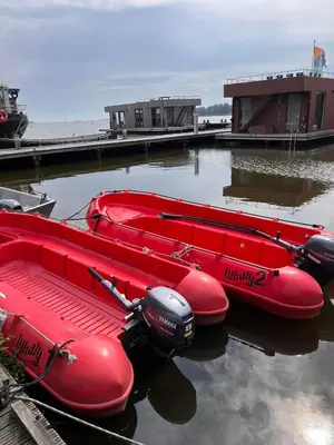 two red canoes are sitting in the water at Houseboat Tomio near Amsterdam in Monnickendam