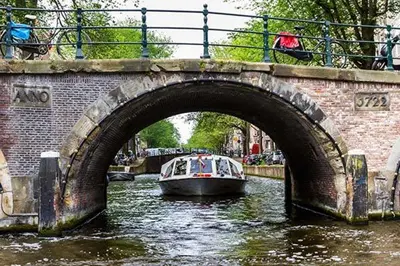 a boat traveling down a river under a bridge at Houseboat Tomio near Amsterdam in Monnickendam