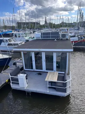 a small boat is docked at a marina at Comfi Houseboat Maatrollie in Monnickendam close to Amsterdam in Monnickendam