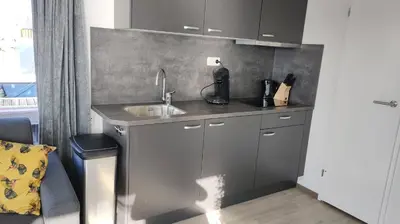 a kitchen with a sink and a counter top at Comfi Houseboat Maatrollie in Monnickendam close to Amsterdam in Monnickendam