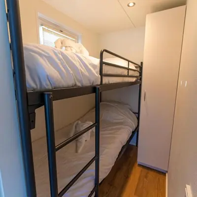 a couple of bunk beds in a room at Comfi Houseboat Maatrollie in Monnickendam close to Amsterdam in Monnickendam