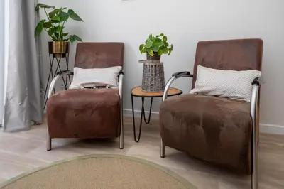 two chairs and a table in a room at Appartement Meer-C in Zandvoort