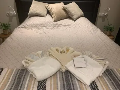 a bed with white towels and a card on it at Appartement Meer-C in Zandvoort