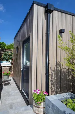 a small building with a door and some flowers at Appartement Meer-C in Zandvoort