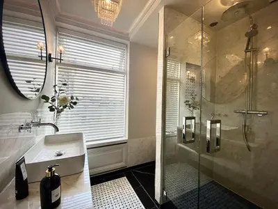 a bathroom with a shower and a sink and a mirror at Suite Canalhouse Majestic in Utrecht