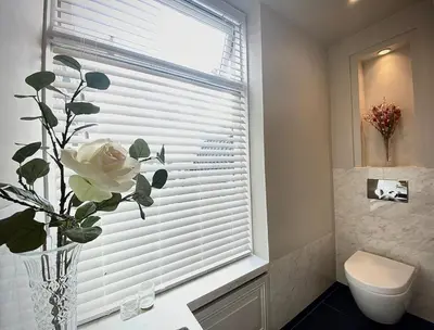 a bathroom with a vase with a flower in a window at Suite Canalhouse Majestic in Utrecht