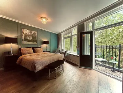 a bedroom with a bed and a large window at Suite Canalhouse Majestic in Utrecht