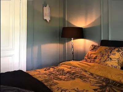 a bedroom with a bed with a lamp on it at Suite Canalhouse Majestic in Utrecht