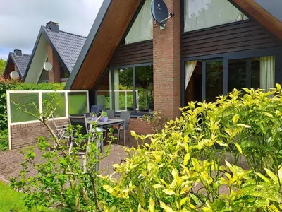 a house with glass windows and a patio at Bungalowpark in Nordholland in Opmeer