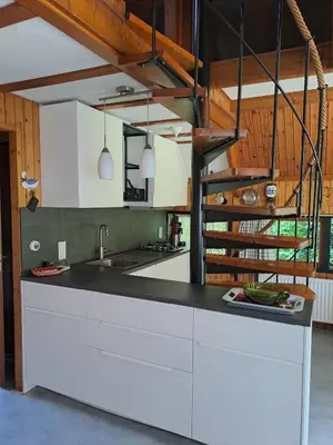 a kitchen with white cabinets and a black counter top at Bungalowpark in Nordholland in Opmeer