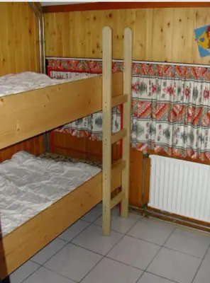two bunk beds in a room with wooden walls at Bungalowpark in Nordholland in Opmeer